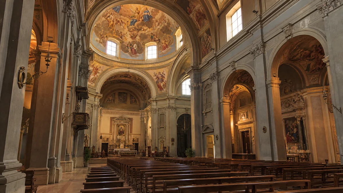Un intérieur d'église Renaissance avec une coupole peinte qui rayonne au-dessus de la croisée